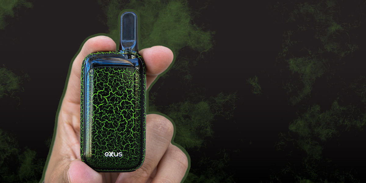 Hand holding a green and black Exxus Rizo device branding against a dark background